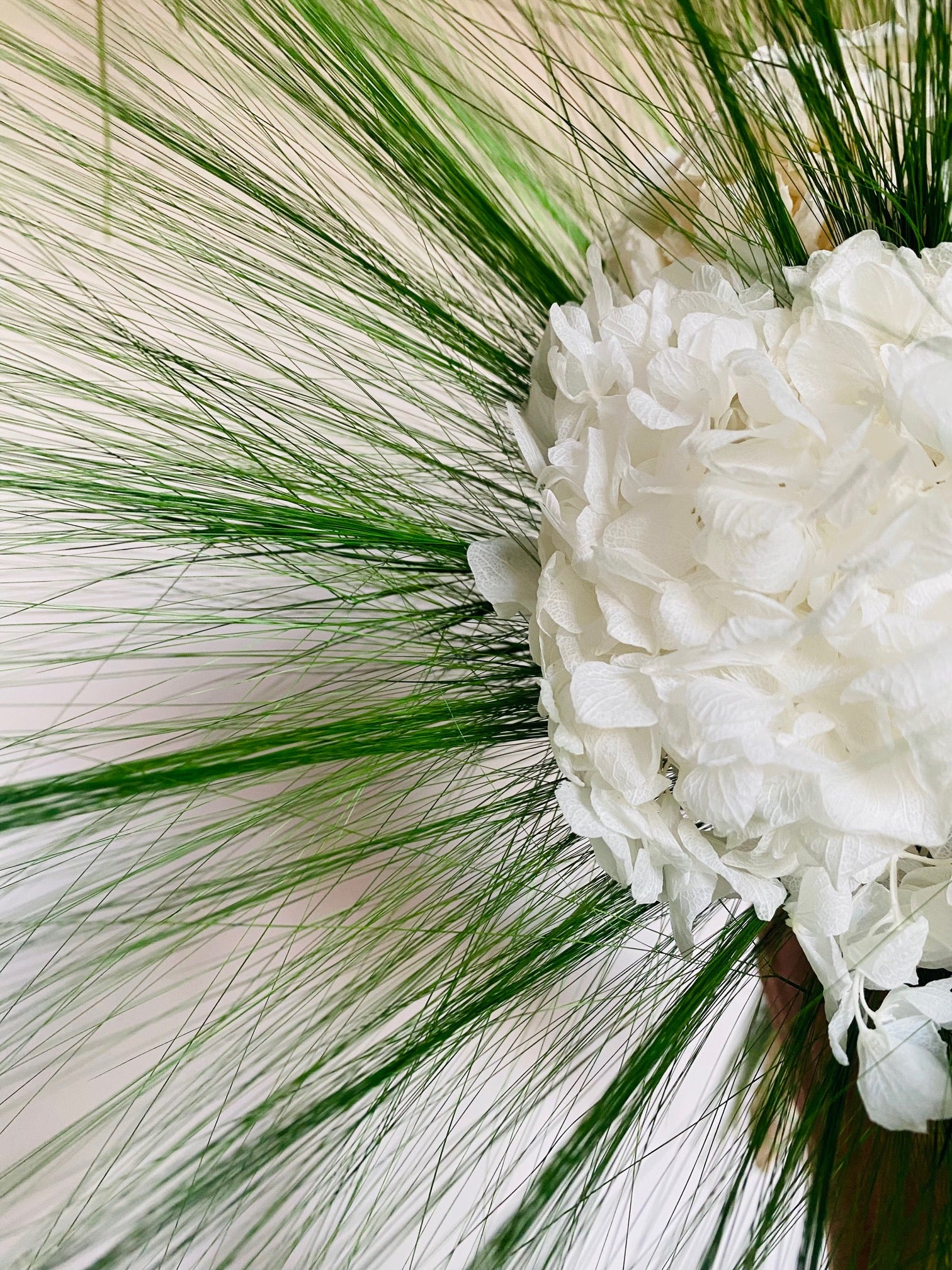 Bouquet de fleurs éternelles Halo Végétal en hortensias stabilisés blancs, décoration végétale haut de gamme, gros plan herbe Barba, effilée et aréienne