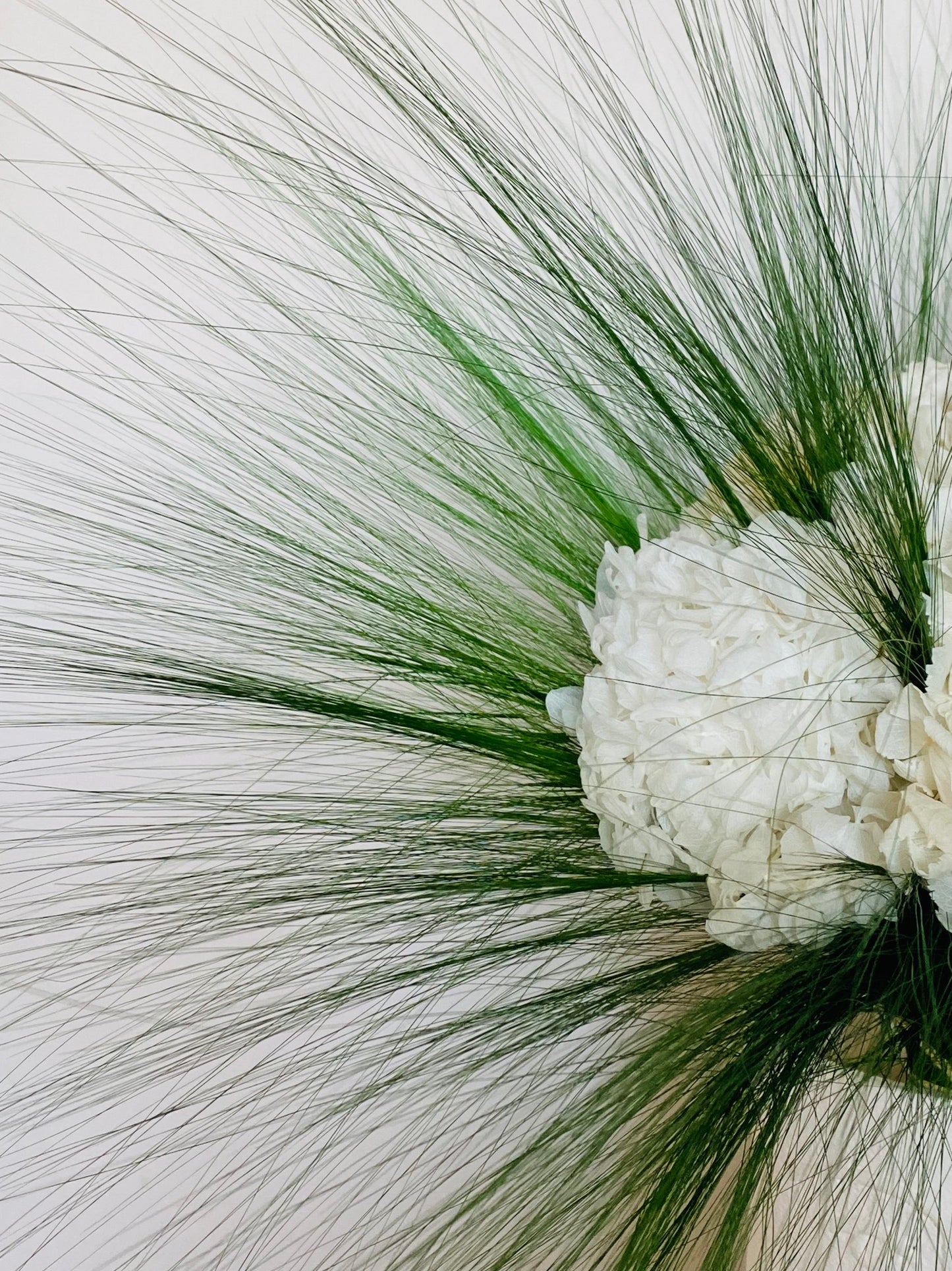 Bouquet de fleurs stabilisées design composé d'hortensias blancs et d'herbe Barba aérienne, vue de côté